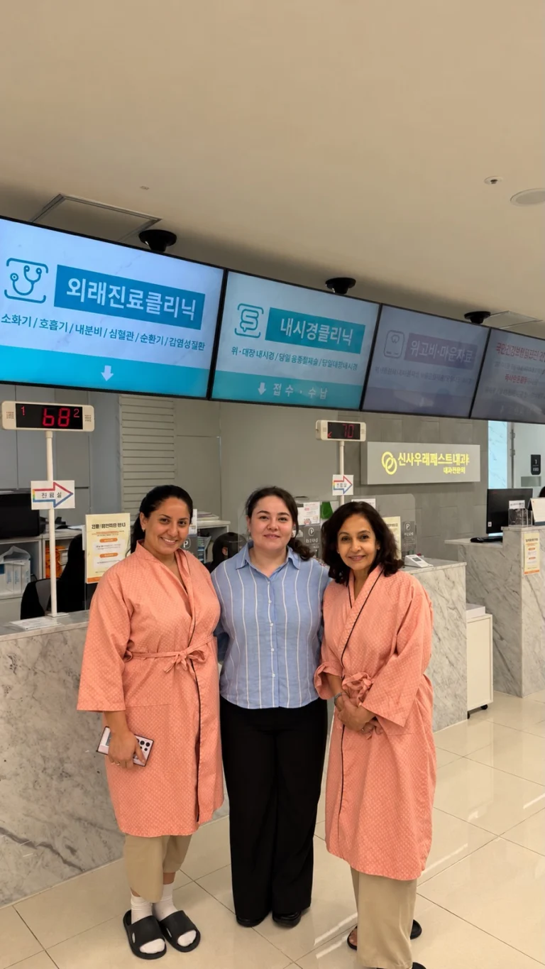 Two patients in check-up gowns with our coordinator at the clinic reception