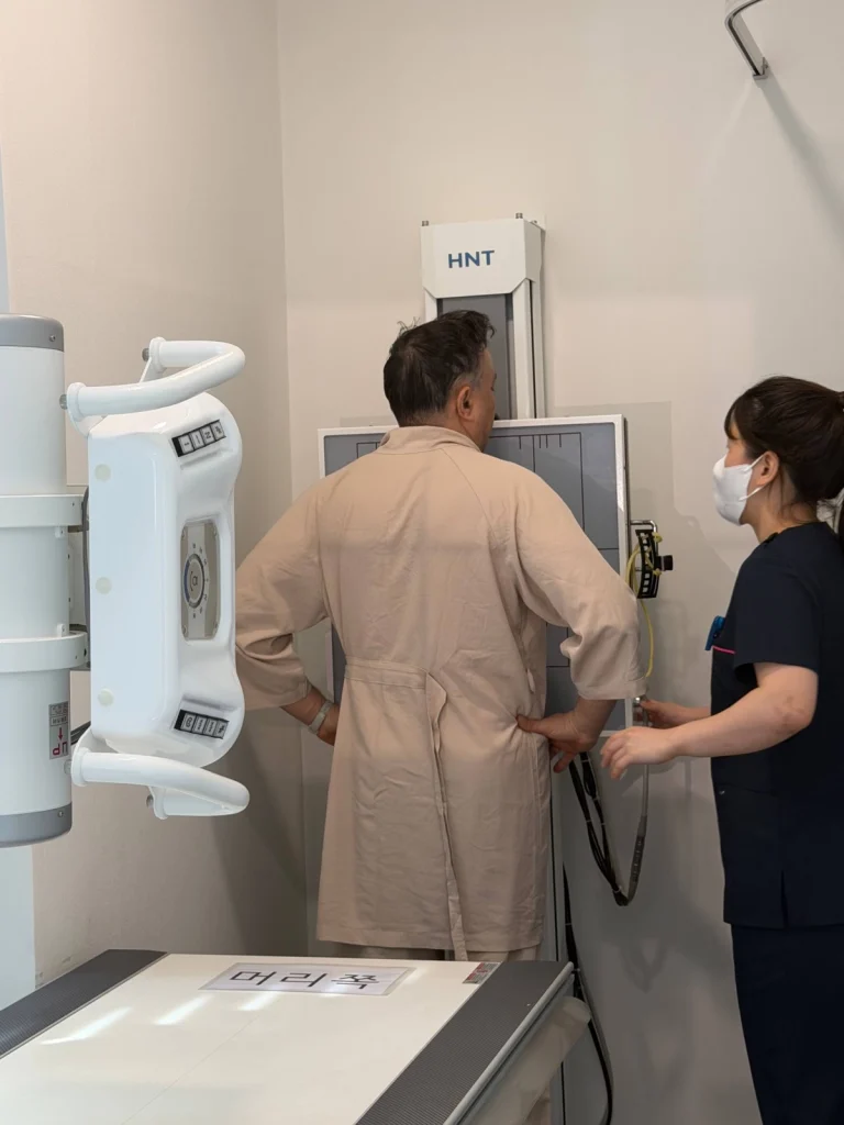 A radiographer positions a patient for a chest X-ray