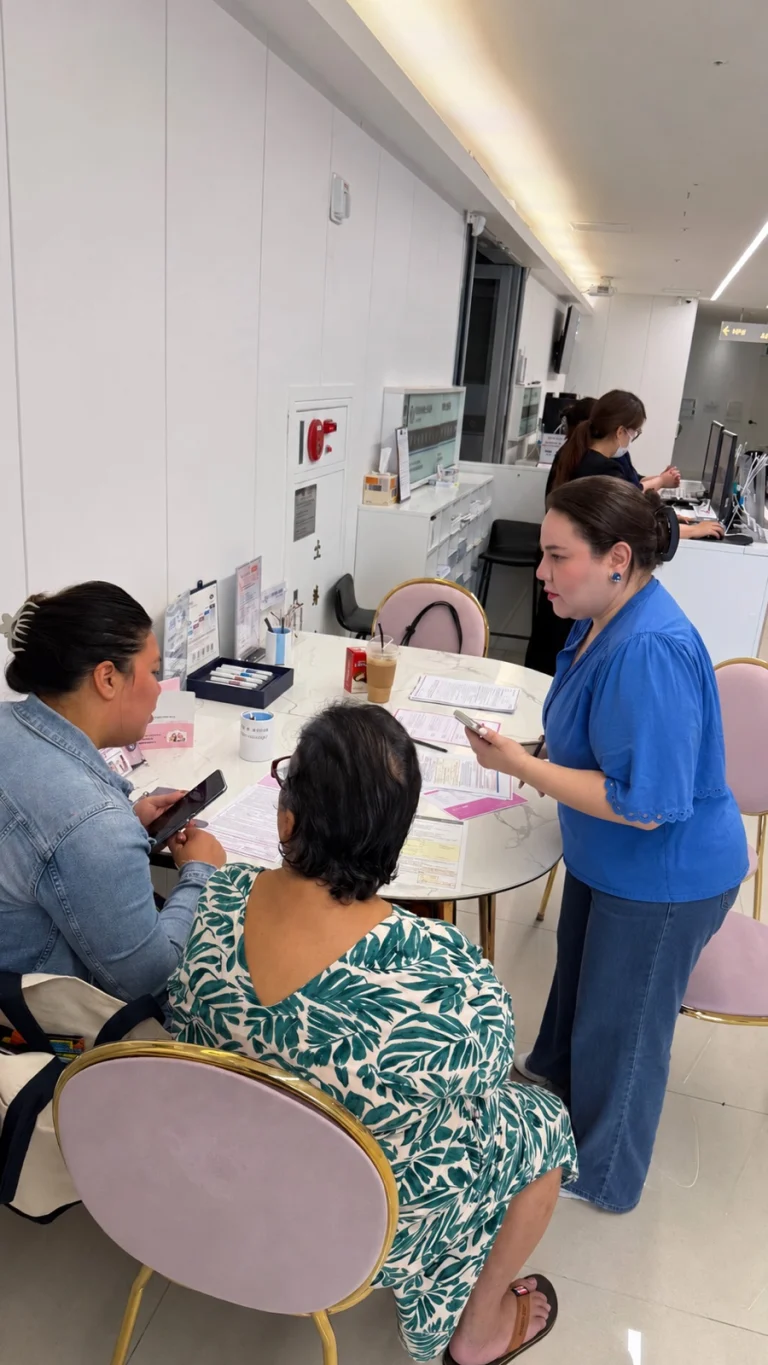 Patients talk with clinic staff at the reception desk