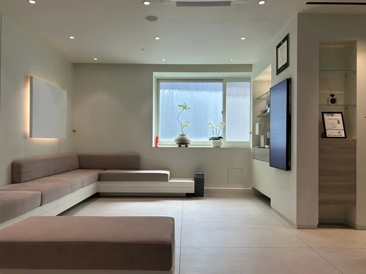 Waiting lounge with a corner sofa at lofi esthetic dentistry in Apgujeong